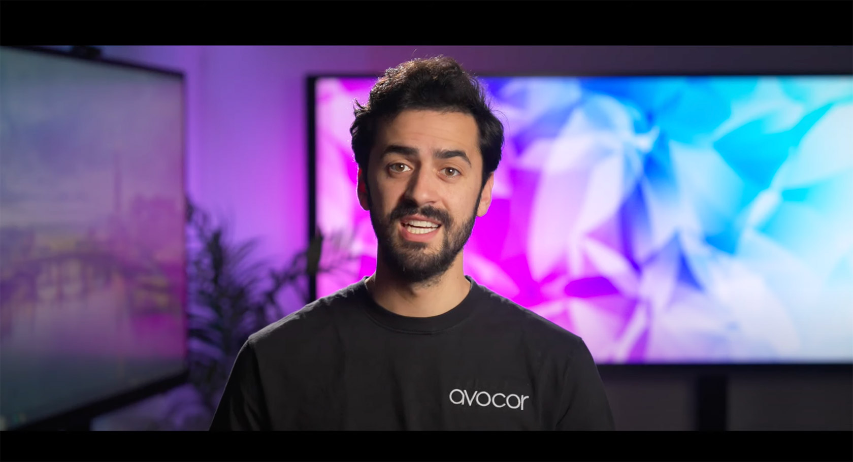 Man explaining Avocor with a background of Display wall